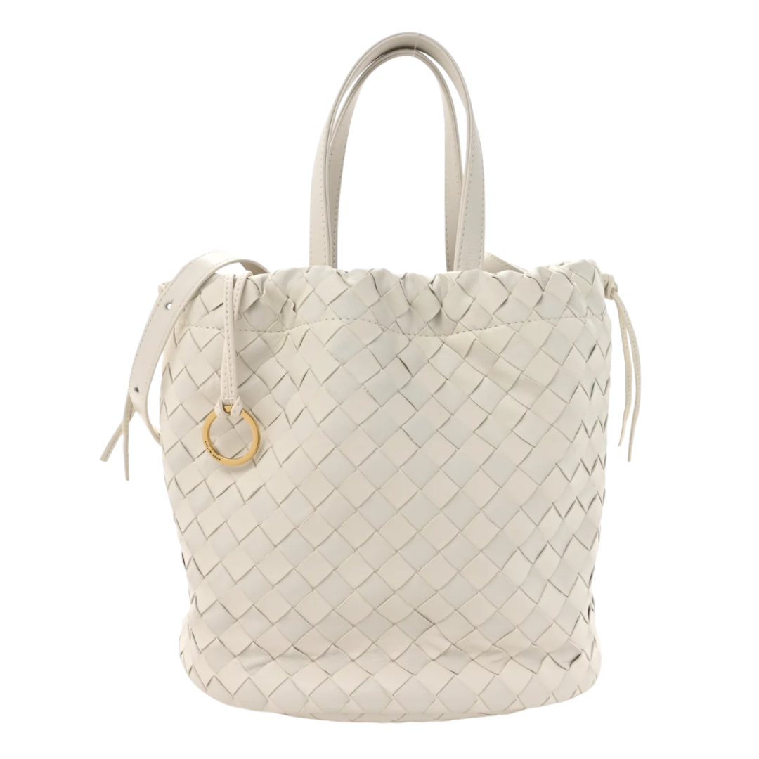 An off-white woven leather bucket bag with double top handles and a small gold-tone ring charm, shown against a plain white background.